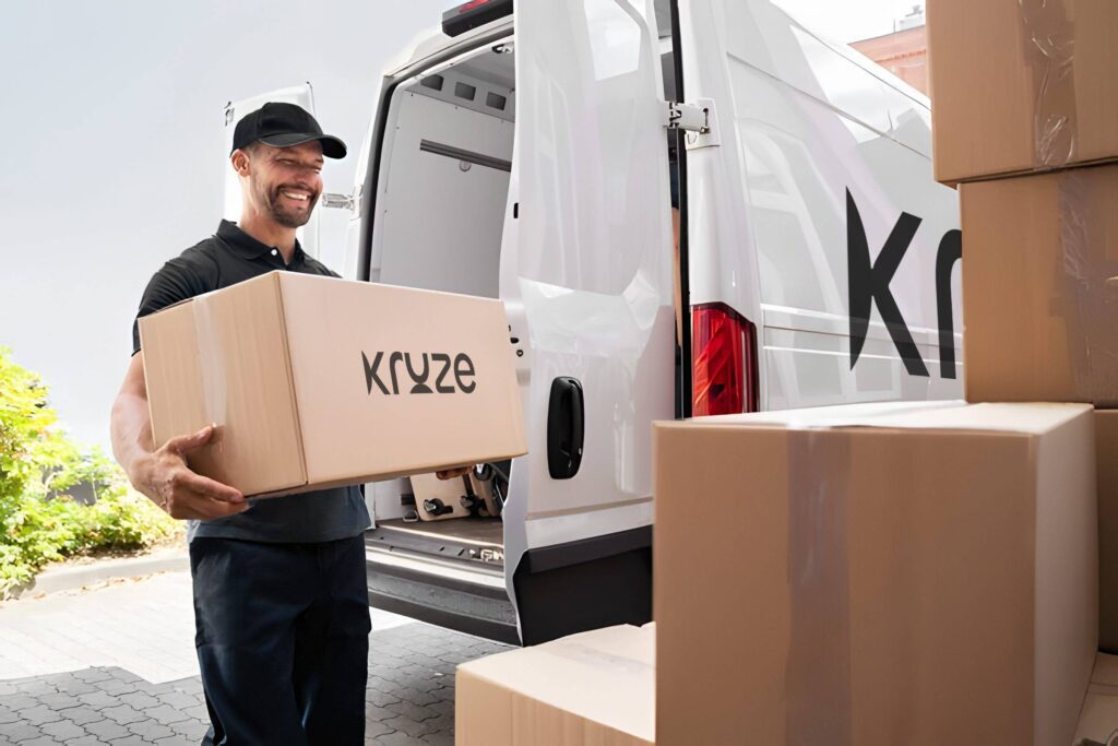 Kruze staff carrying branded moving box beside service van