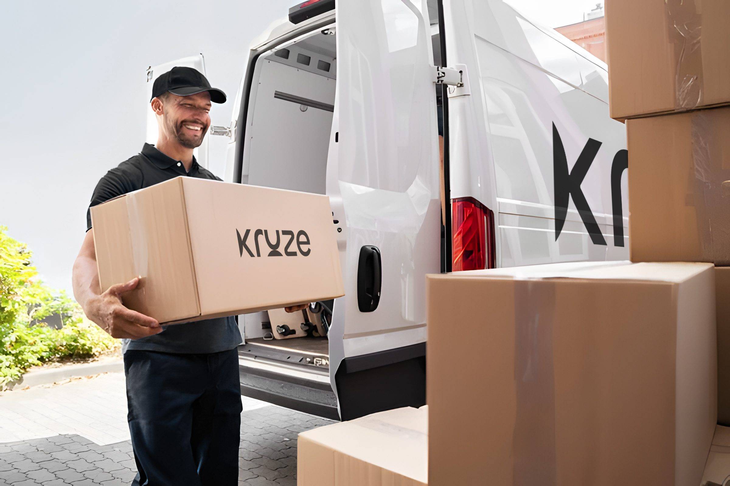 Kruze staff carrying branded moving box beside service van